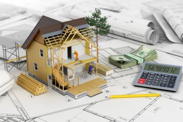 A model house on blueprints with lumber, a pencil, a calculator, cash, and two miniature workers.